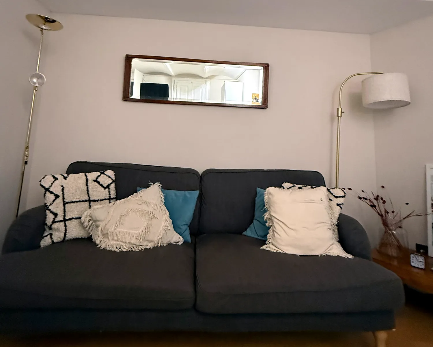 Sala de espera luminosa con sofá gris y cojines
